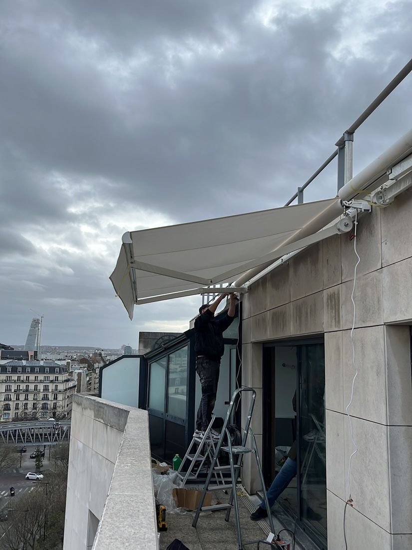 Technicien Store Xpress installant un store banne coffre à Paris