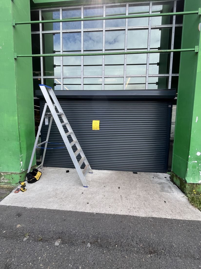 Rideau métallique de commerce en cours d'intervention par un technicien