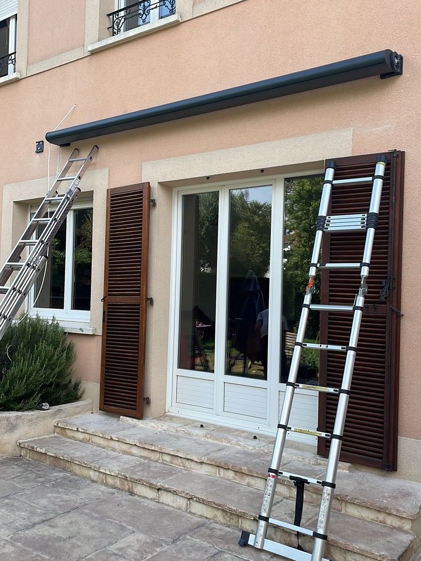 Store banne coffre noir venant d etre pose au-dessus d une porte-fenetre