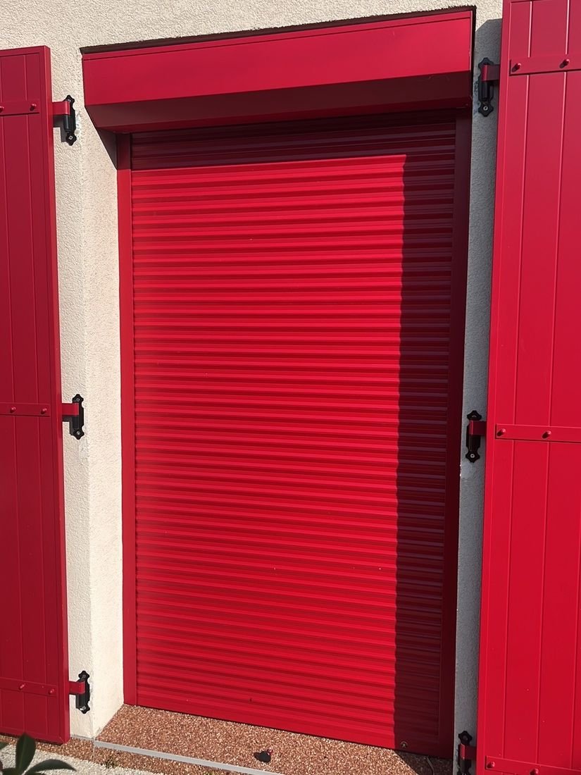 Volet roulant rouge avec coffre assorti pose sur une fenetre de maison